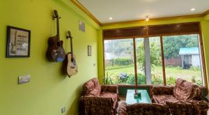 ein Wohnzimmer mit zwei Gitarren an der Wand in der Unterkunft Hotel Nigale in Dhankuta