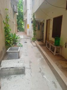 an empty alley in an old building with plants at Om Sai Manjunatha Residency in Puttaparthi