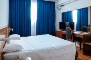 a bedroom with a bed and a desk with a computer at Hotel Cavallino in Faenza +26 photos