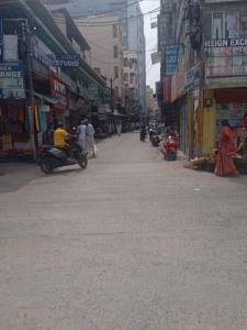 an empty street in a city with people riding motorcycles at Om Sai Manjunatha Residency in Puttaparthi