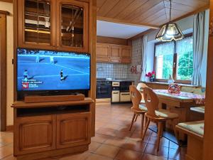 a kitchen with a tv and a table with chairs at Il Nido casa vacanze in Varena +23 photos