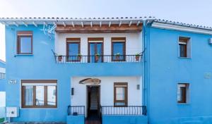 a blue and white house with a balcony at EL RINCÓN DE DENVER in Suances