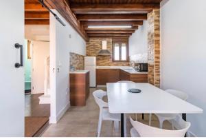 a kitchen and dining room with a white table and chairs at EL RINCÓN DE DENVER in Suances