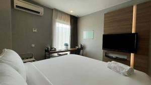 a bedroom with a bed and a flat screen tv at The Leverage Business Hotel - Rawang in Rawang