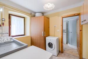 a bathroom with a washing machine and a sink at Holiday house Pod Ledinco in Most na Soči +34 photos