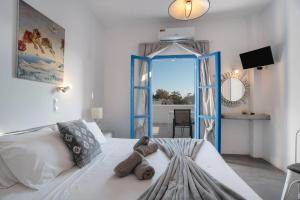 a bedroom with a white bed and a mirror at Pleasure Blackbeach Studios in Perissa