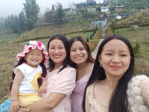 three women and a little girl posing for a picture at Dhim in Mangpu +2 photos