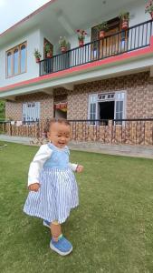 a baby doll standing in front of a house at Dhim in Mangpu