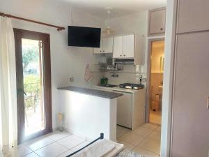 a kitchen with white cabinets and a counter top at Grammatoula in Nikiana +40 photos