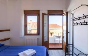 a bedroom with a blue bed and a balcony at EL RINCÓN DE DENVER in Suances
