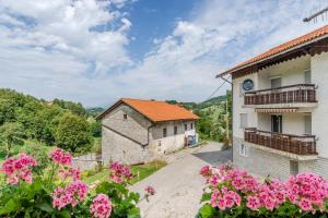 a building with pink flowers in front of it at Holiday house Pod Ledinco in Most na Soči