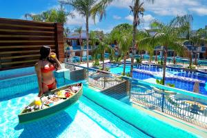 a woman in a boat in a pool at a resort at Arte da Natureza Hotel Bonito in Bonito