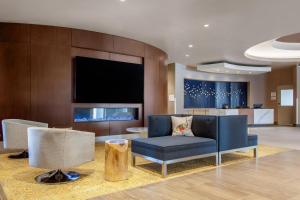 a living room with a blue couch and a tv at Cambria Hotel Phoenix Chandler - Fashion Center in Chandler