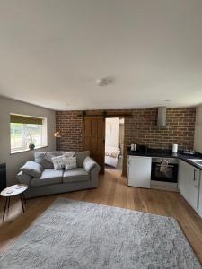 a living room with a couch and a kitchen at Gatwick 'Bit on the Side' in Copthorne +10 photos