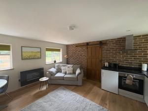 a living room with a couch and a brick wall at Gatwick 'Bit on the Side' in Copthorne