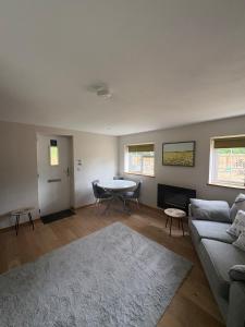 a living room with a couch and a table at Gatwick 'Bit on the Side' in Copthorne