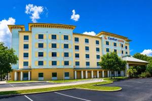 an image of a hotel with a parking lot at Comfort Suites Palm Bay - Melbourne in Palm Bay