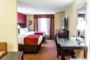 a hotel room with a bed and a desk at Comfort Suites Palm Bay - Melbourne in Palm Bay +28 photos