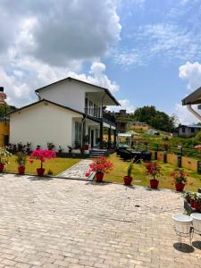 a white house with potted plants in front of it at Aranya Villa in Bākhri Kharka