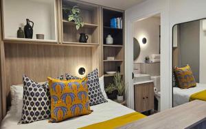 a bedroom with two beds with pillows on it at High-Floor Modern Apartment - Rooftop Pool & Table Mountain Views in Cape Town
