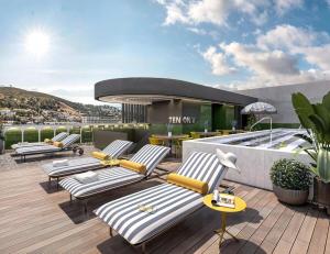 a rooftop deck with lounge chairs and a swimming pool at High-Floor Modern Apartment - Rooftop Pool & Table Mountain Views in Cape Town +4 photos