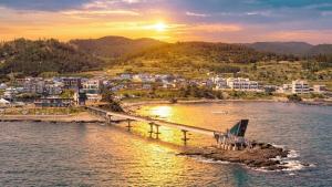 a bridge over a body of water with a city at Pohang Baritdol Pension in Pohang
