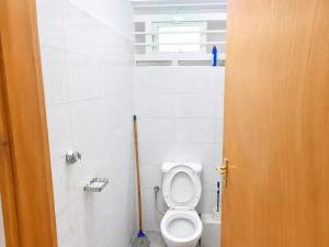 a bathroom with a toilet with a mop in it at Annie's studio near Westside mall in Nakuru