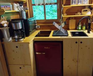 a kitchen with a red dishwasher in a wooden kitchen at Ferienhaus Eulennest in Hilders