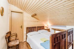 a bedroom with a bed and a wooden ceiling at Farmhouse Cvetje in Tolmin +57 photos