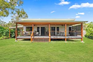 a modular home with a large deck on a lawn at The Luxe Breeze Bungalow in Hervey Bay
