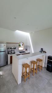 a kitchen with a counter with two stools and a sink at Sari Hills Bali in Nusa Dua