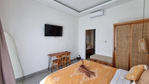 a bedroom with a bed and a tv on the wall at Sari Hills Bali in Nusa Dua