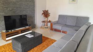 a living room with a couch and a flat screen tv at Villa HASSANI BEACH FOULPOINTE in Foulpointe