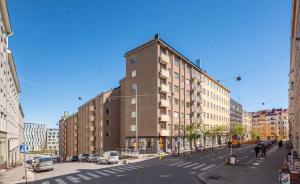 a tall building on a city street with cars at City Home Kalliossa in Helsinki