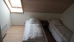 two beds in a small room with a window at Central located Large apartment on the 1st floor tv in Hjørring