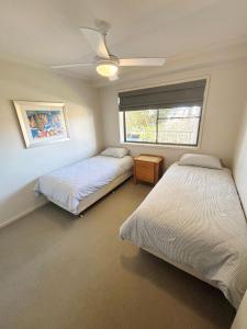 a bedroom with two beds and a window at Jubilee Apartment 11 - Bring your own linen in South West Rocks +12 photos
