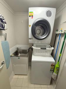 a kitchen with a washing machine and a sink at Jubilee Apartment 11 - Bring your own linen in South West Rocks