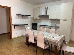 a kitchen with a table with pink chairs and a kitchen with a stove at Ale Mac in Carrao