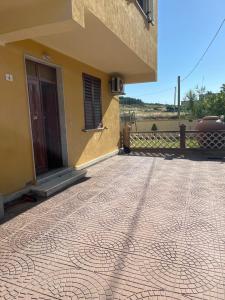 a building with a tiled floor in front of a house at Ale Mac in Carrao