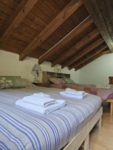 a bedroom with a bed with white towels on it at Eco Mountain Green House in Bienno