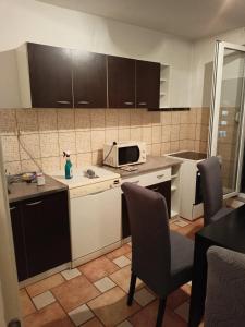 a small kitchen with a microwave and chairs in it at njegoševa in Derventa