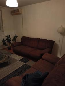 a living room with a brown couch and a table at njegoševa in Derventa