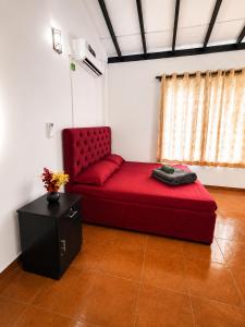 a red couch in a room with a table at Sattvic Ceylon- Wellness Homestay in Colombo