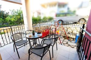 a table and chairs on a balcony with a playground at Lina's House in Syvota