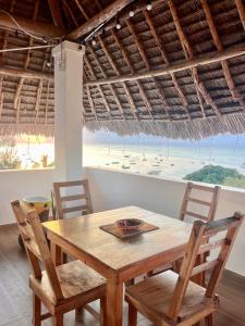 a wooden table and chairs with a view of the beach at Aurora Nungwi in Nungwi