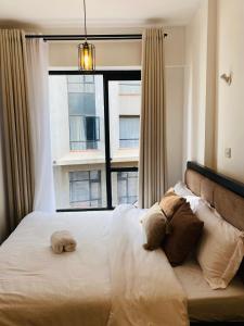 a bedroom with a large bed with a window at Nomads nest suites in Kiambu