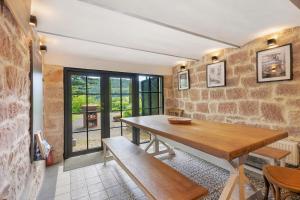 a dining room with a wooden table and a bench at Waldwagen Altes Forstamt Sinntal in Sinntal +12 photos