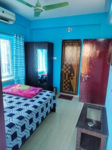 a bedroom with a bed and a table in it at Priya guest house in Howrah +1 photo