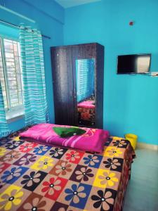 a bedroom with a bed with a colorful blanket at Priya guest house in Howrah