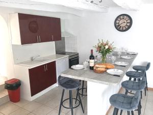 a kitchen with a table with bread and wine bottles at Gîte ô scope-2km du futuroscope- linges et ménage inclus in Jaunay-Clan